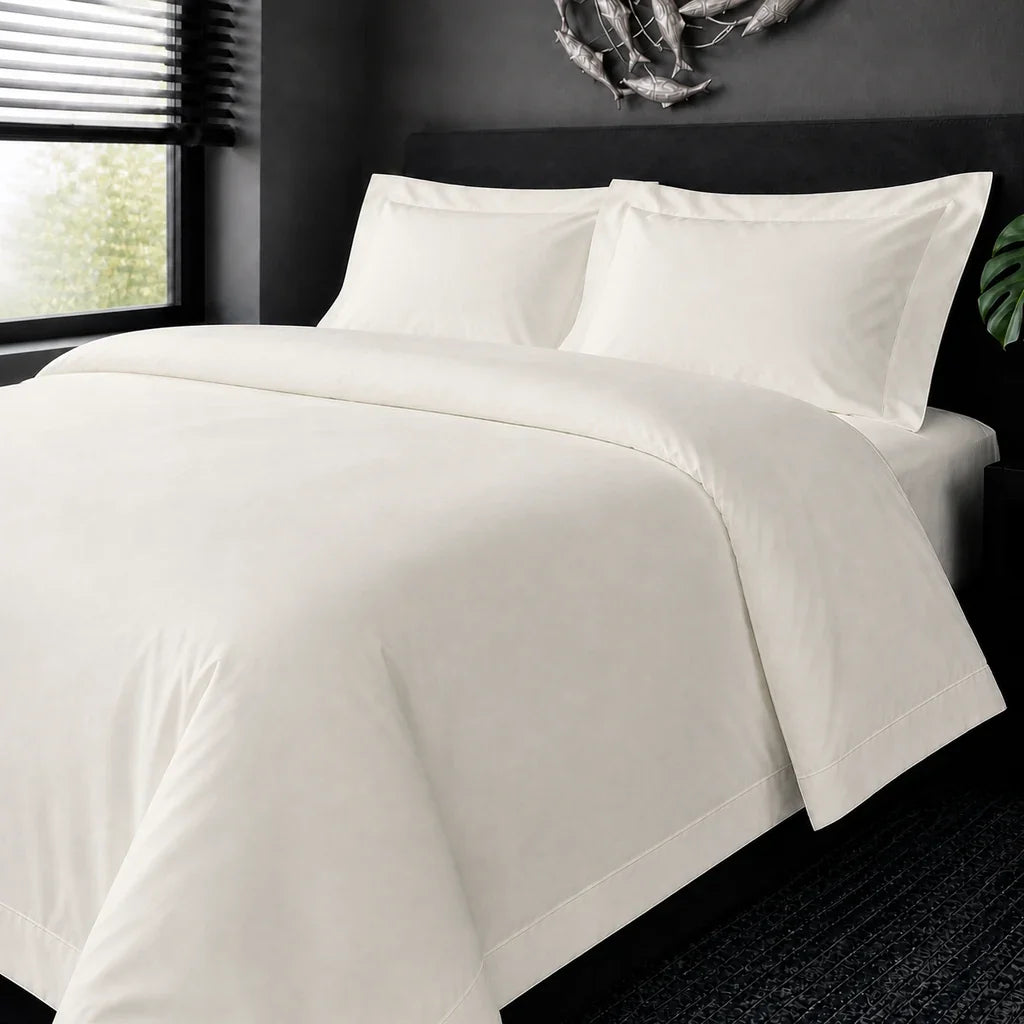 Cream cotton 200TC Oxford duvet cover set with cream one-row satin stitch – on-bed view | Linen & Co