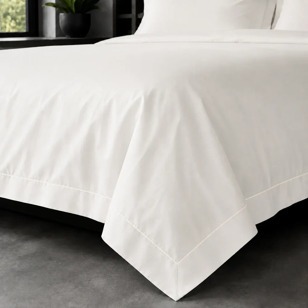 Cream polycotton percale 200TC Oxford duvet cover on bed with cream one-row satin stitch – on-bed view | Linen & Co