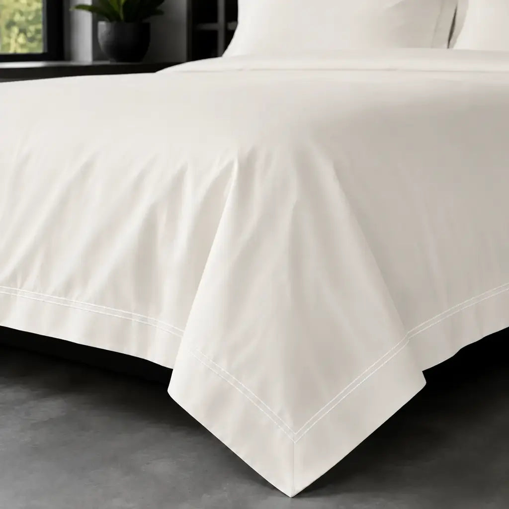Cream polycotton percale 200TC Oxford duvet cover on bed with white two-row satin stitch - Linen and Co