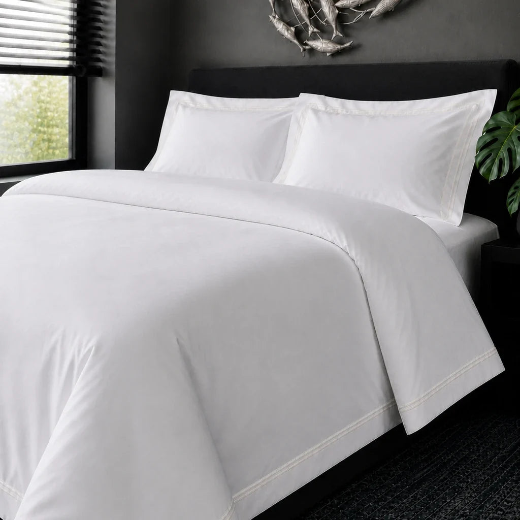 White cotton 200TC Oxford duvet cover set with cream two-row satin stitch – on-bed view | Linen & Co