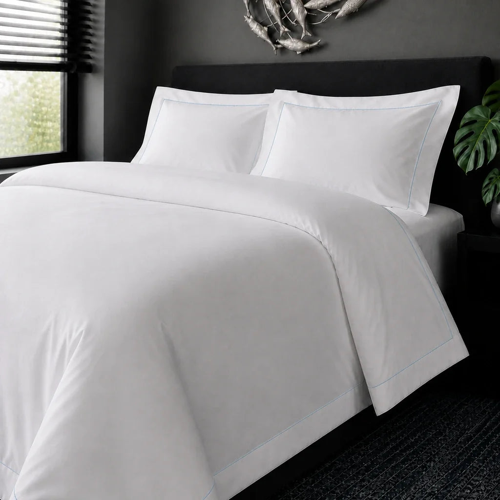 White cotton 200TC Oxford duvet cover set with duck egg one-row satin stitch – on-bed view | Linen & Co