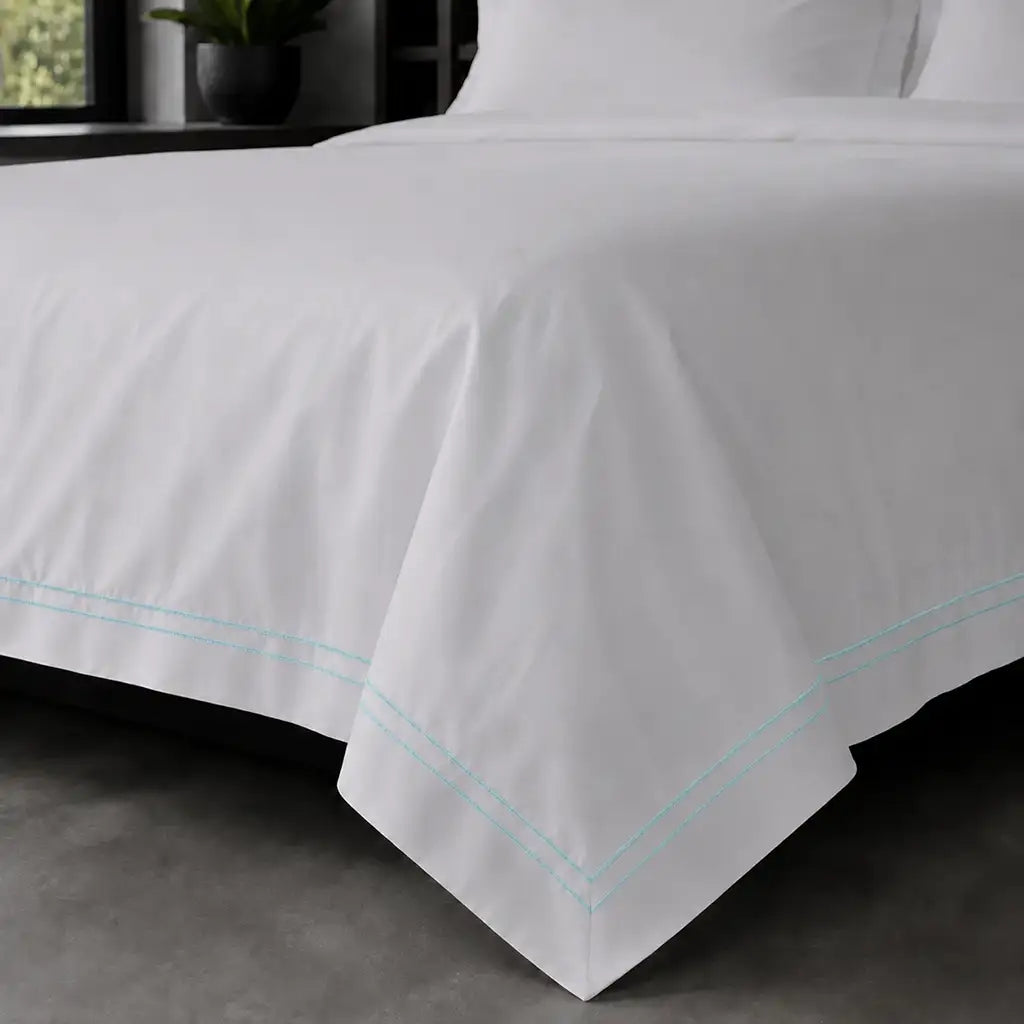 White polycotton percale Oxford duvet cover set with duck egg two-row satin stitch – on-bed view | Linen & Co