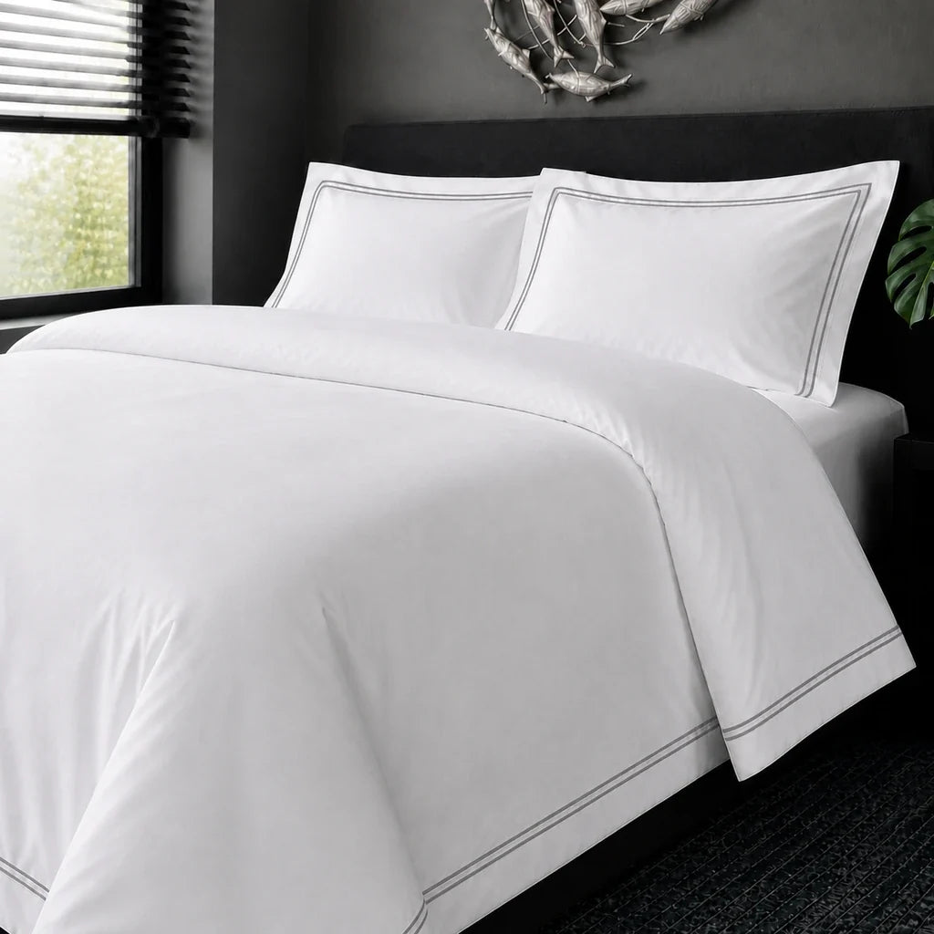 White cotton 200TC Oxford duvet cover set with grey two-row satin stitch – on-bed view | Linen & Co