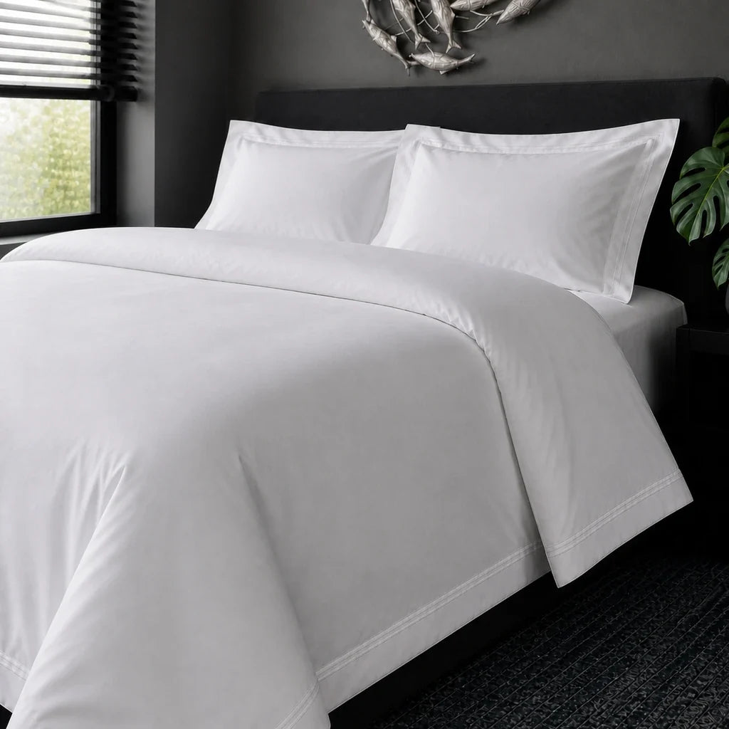 White cotton 200TC Oxford duvet cover set with white two-row satin stitch – on-bed view | Linen & Co
