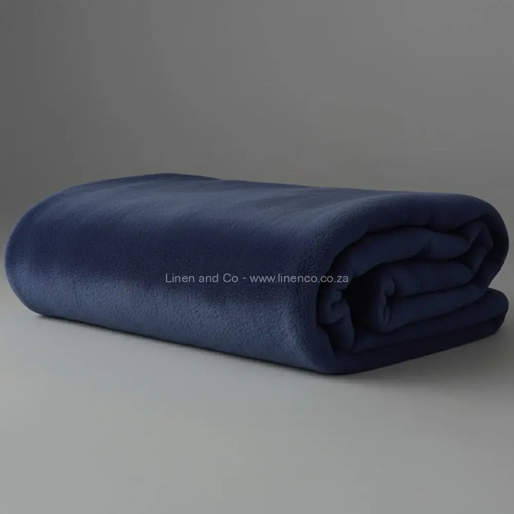 Navy Belfiore luxury blanket neatly folded on light grey background - premium hospitality textile.