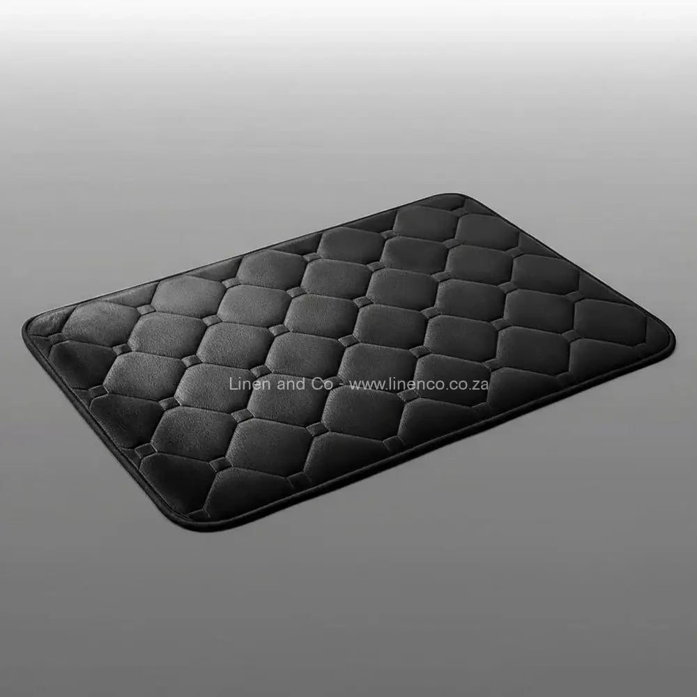 Charcoal memory foam bath mat by Linen & Co on soft grey gradient background, 50x80cm luxury microfibre bathroom accessory with non-slip backing