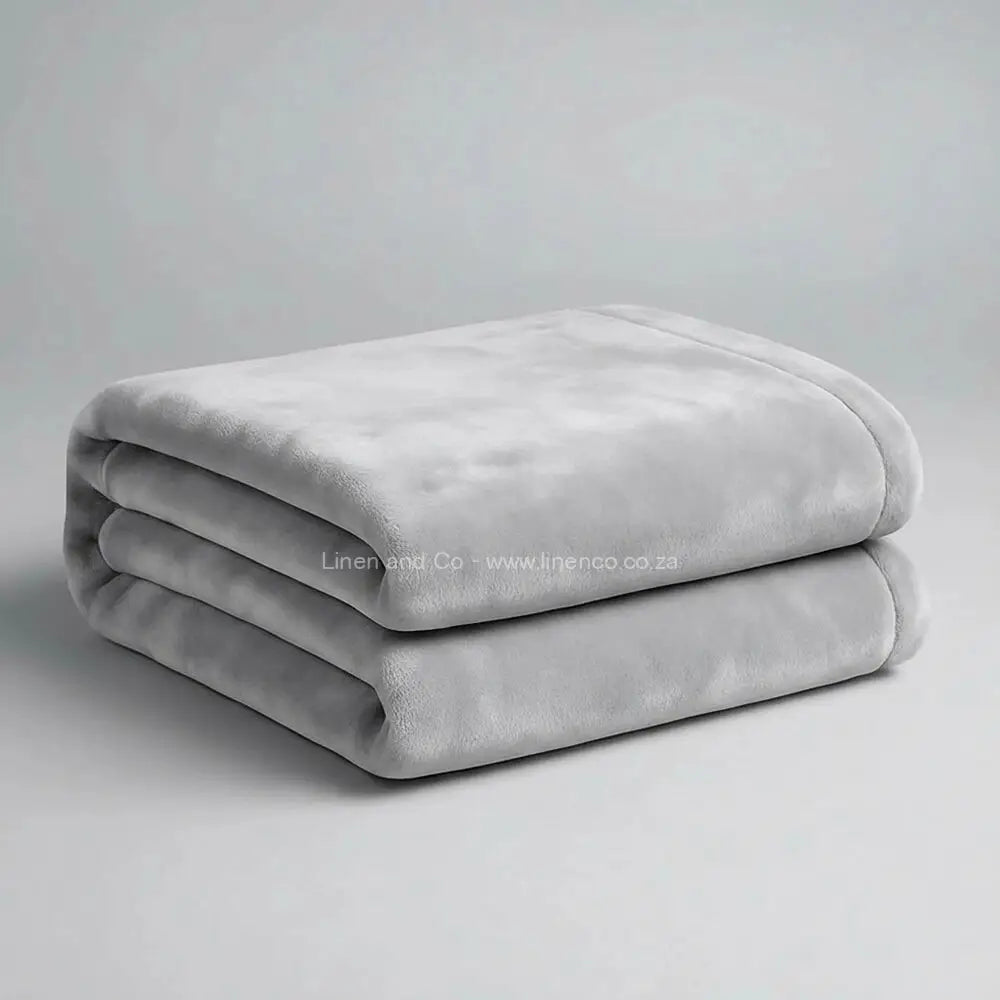 Dove grey luxury plush blanket neatly folded on light grey background - Linen and Co premium microfibre hospitality blanket