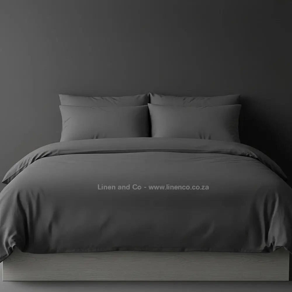 Grey percale duvet cover set from Linen and Co, showcasing pristine white bedding against a dark grey background, demonstrating clean and professional hospitality textile design