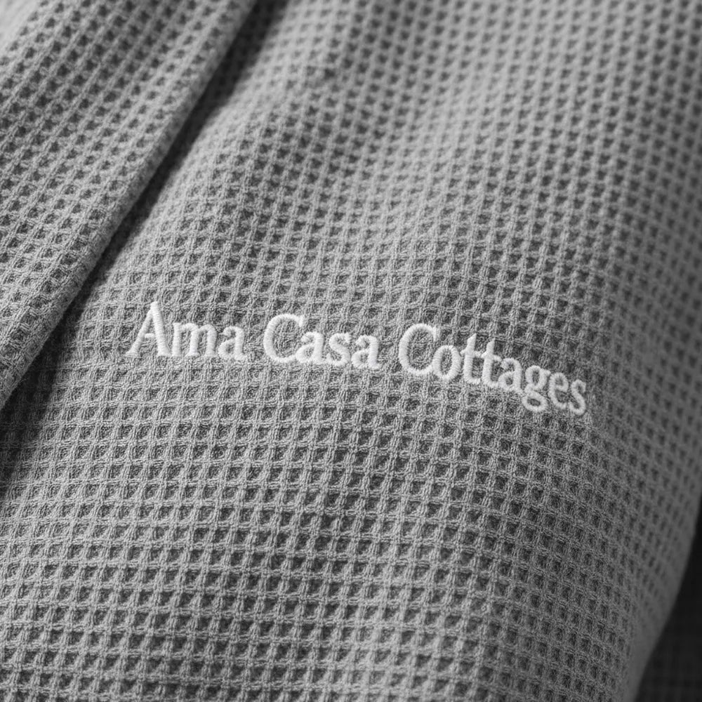 Custom embroidered logo on grey waffle weave gown by Linen and Co - premium hospitality towel branding detail