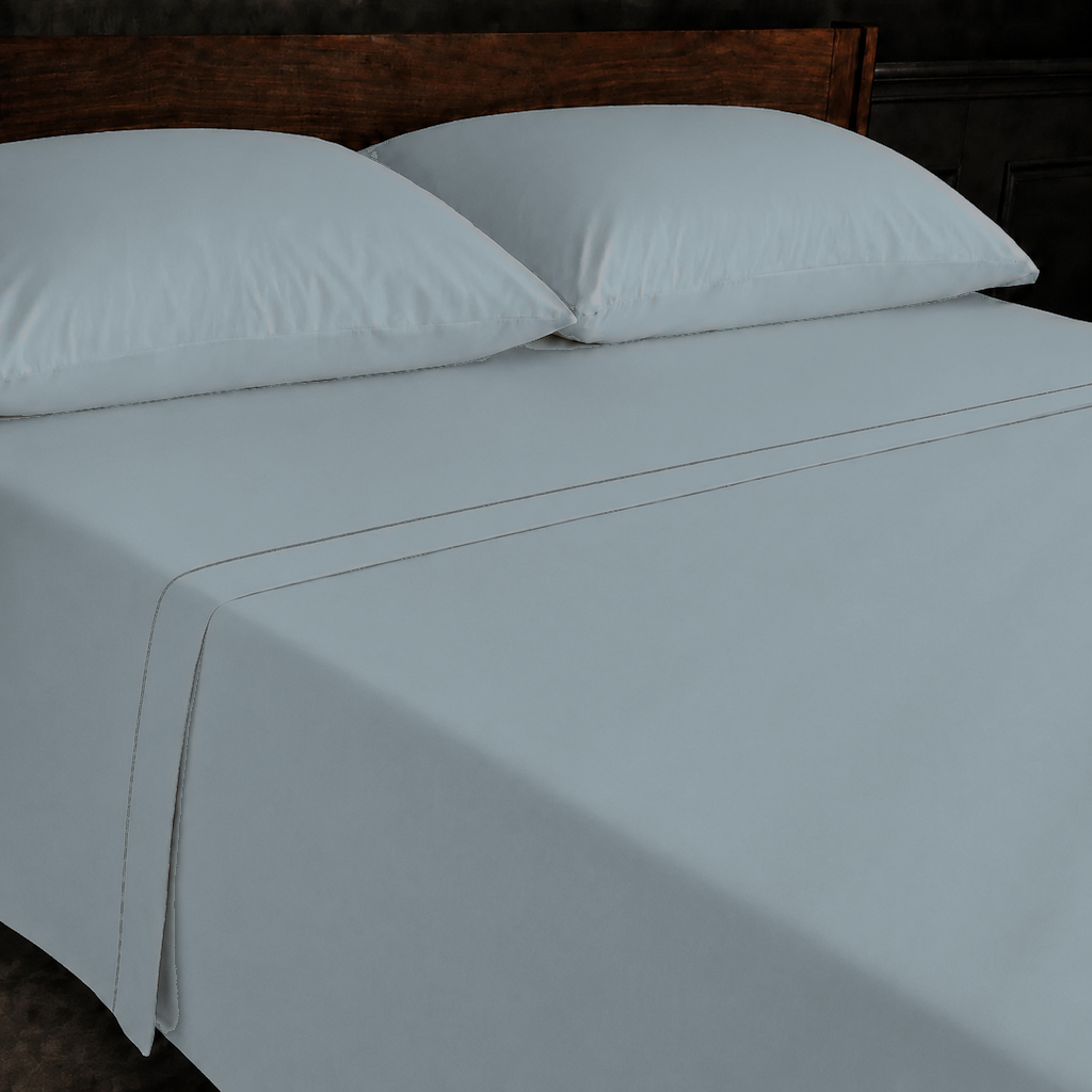 Duck Egg polycotton percale 200TC flat sheet with Grey one-row satin stitch — on the bed.