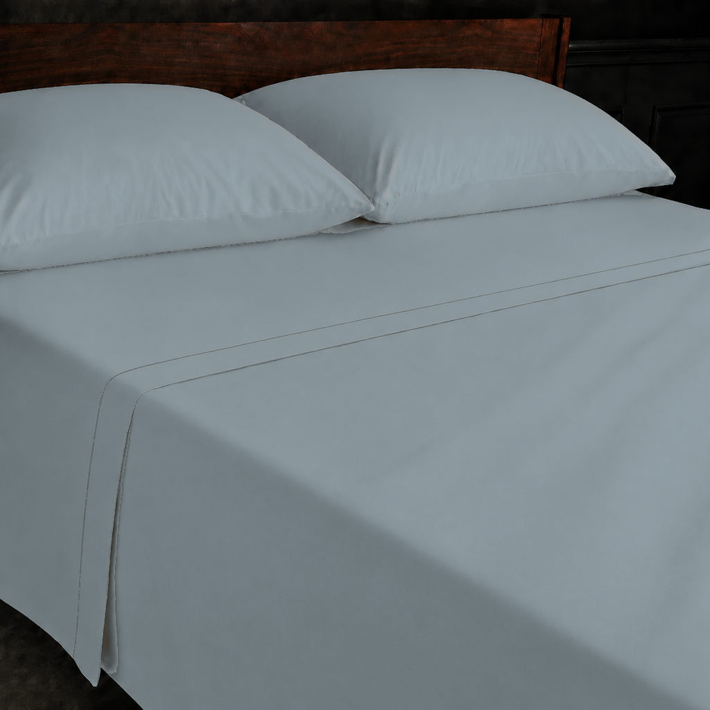 Duck Egg polycotton percale 200TC flat sheet with Stone one-row satin stitch — on the bed.