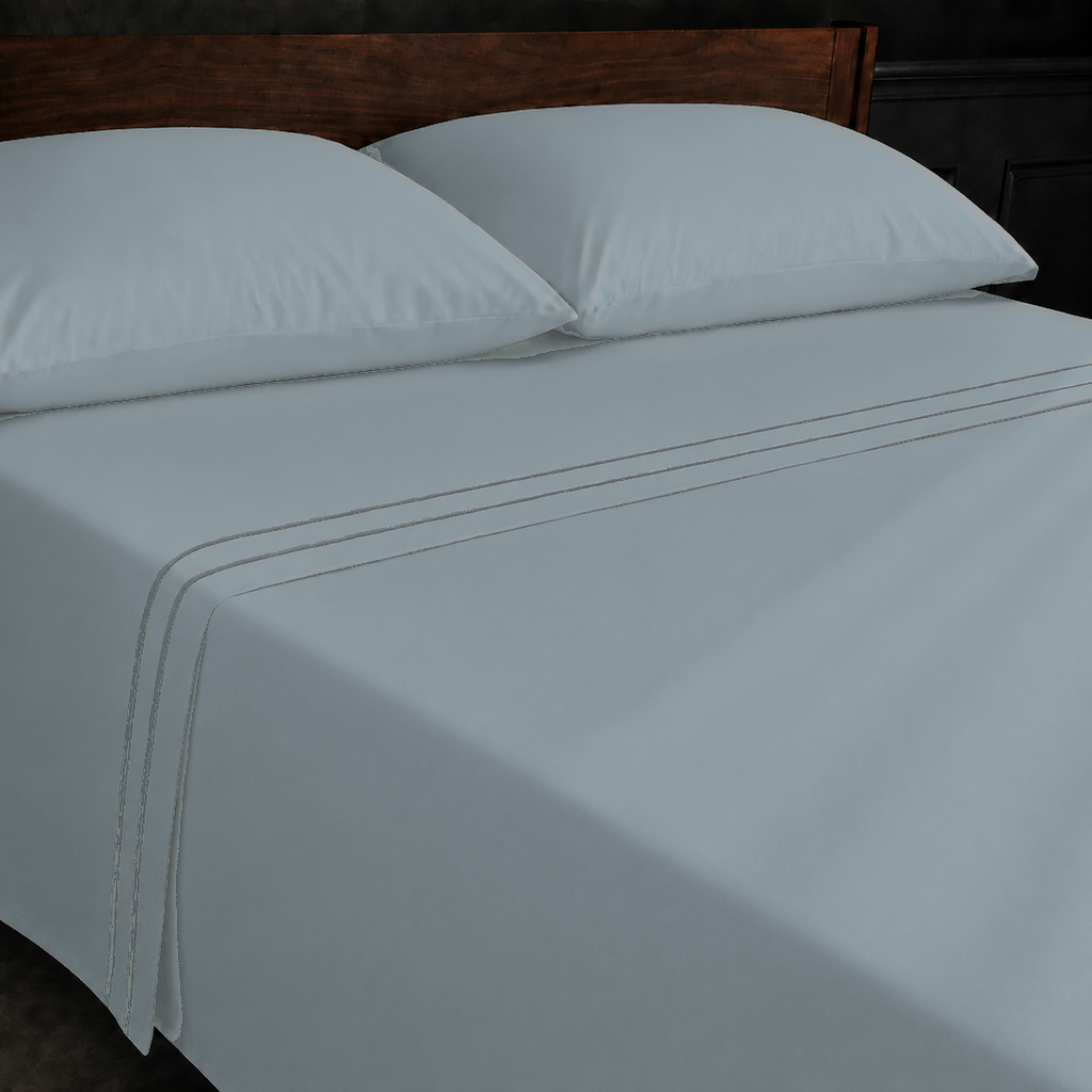 Duck Egg polycotton percale 200TC flat sheet with Grey two-row satin stitch — on the bed.