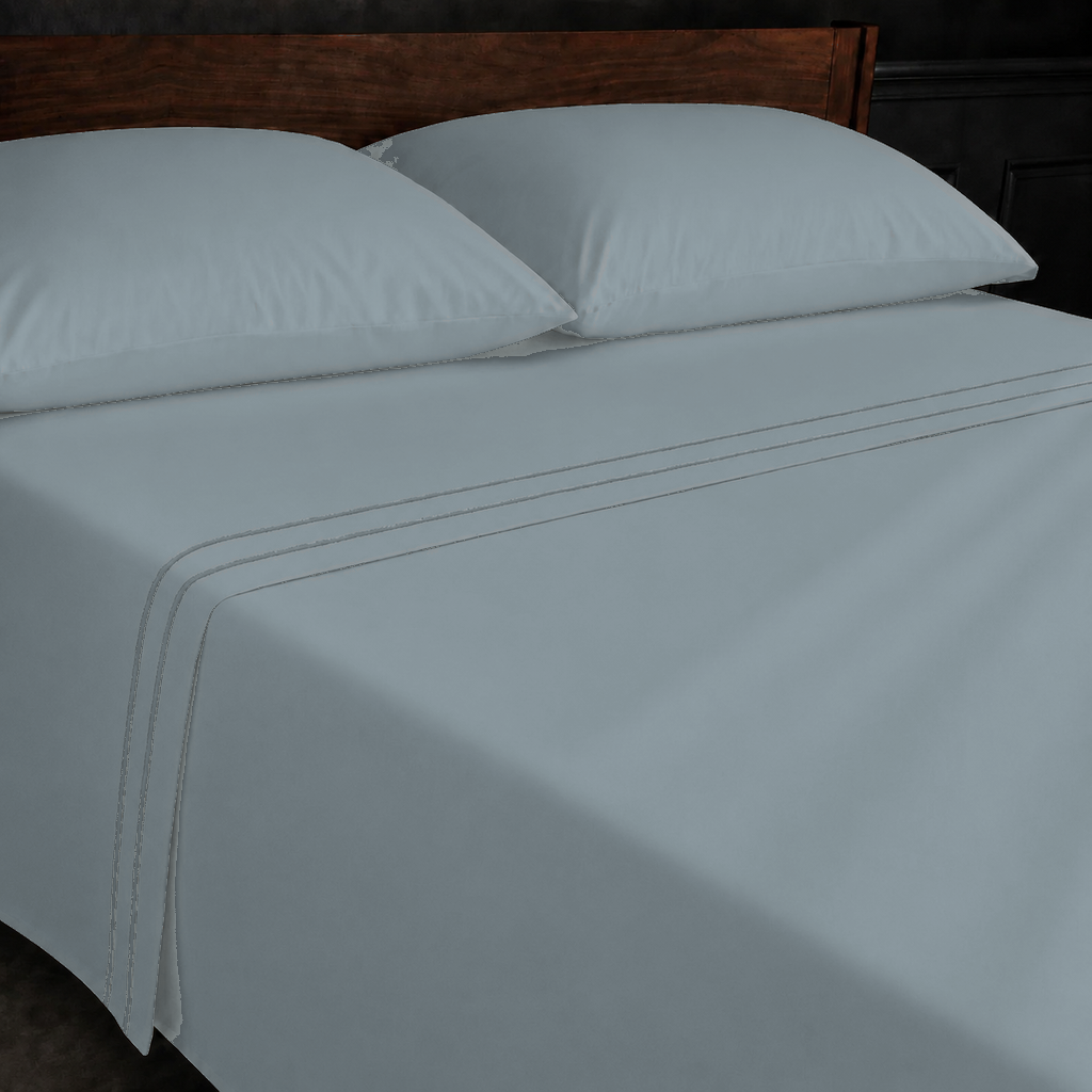 Duck Egg polycotton percale 200TC flat sheet with Stone two-row satin stitch — on the bed.