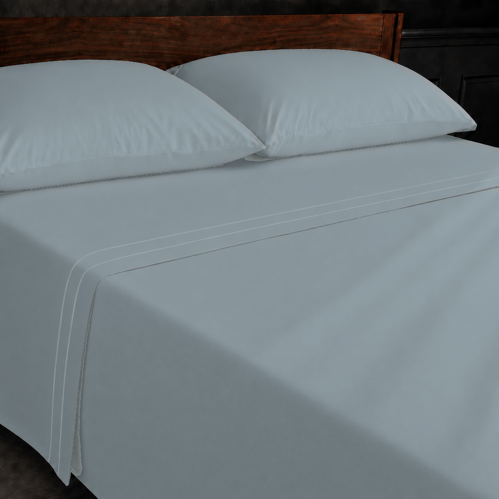 Duck Egg polycotton percale 200TC flat sheet with White two-row satin stitch — on the bed.