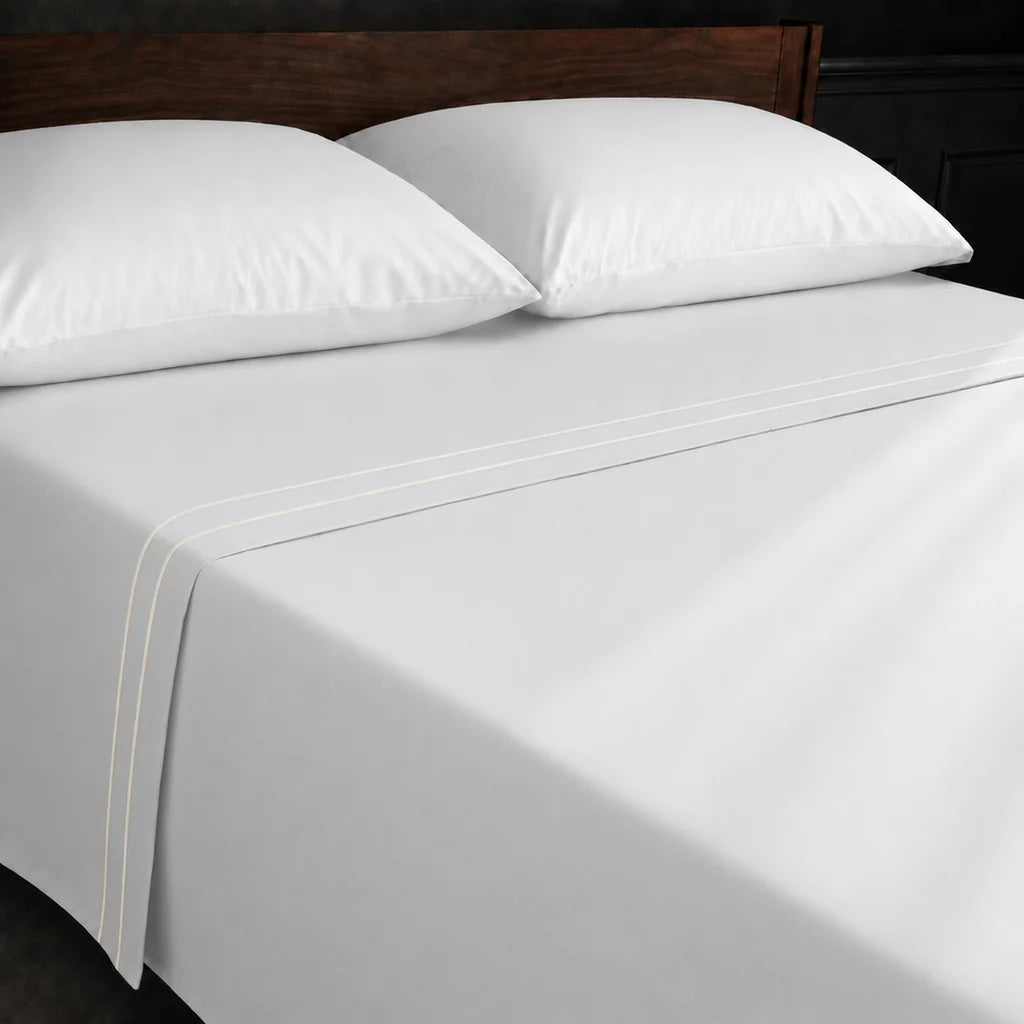White Polycotton Percale 200TC flat sheet with Cream two row satin stitch - on the bed - Linen and Co