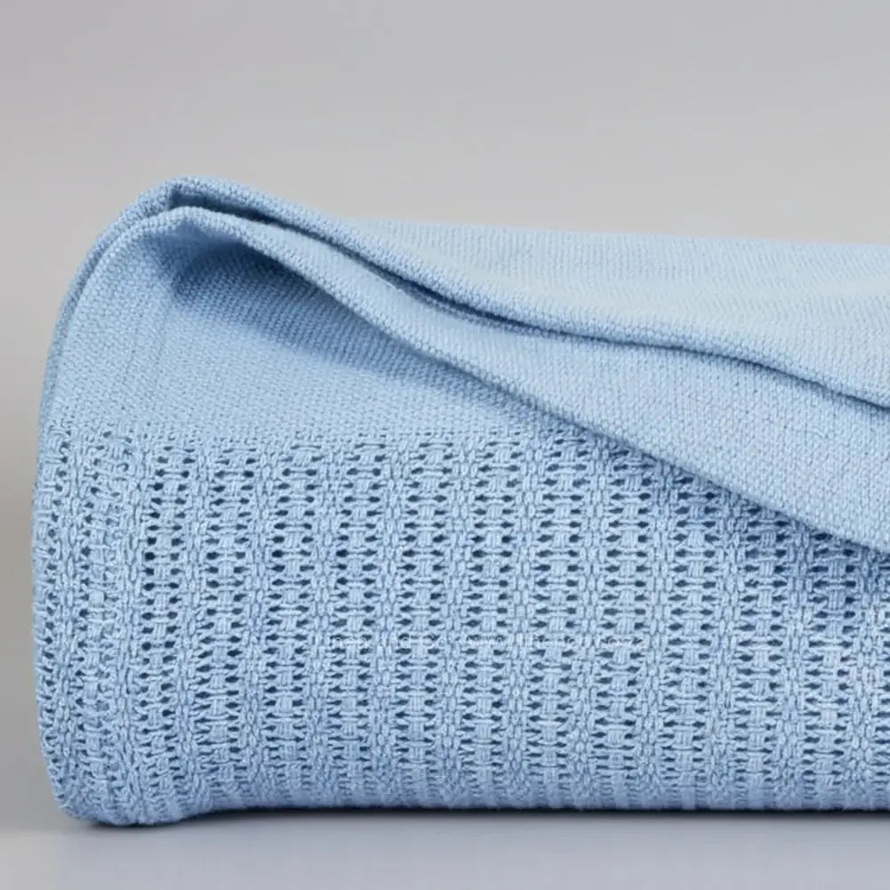 blue cotton cellular blanket showing textured waffle weave fabric on neutral grey background—soft, breathable bedding by Linen & Co