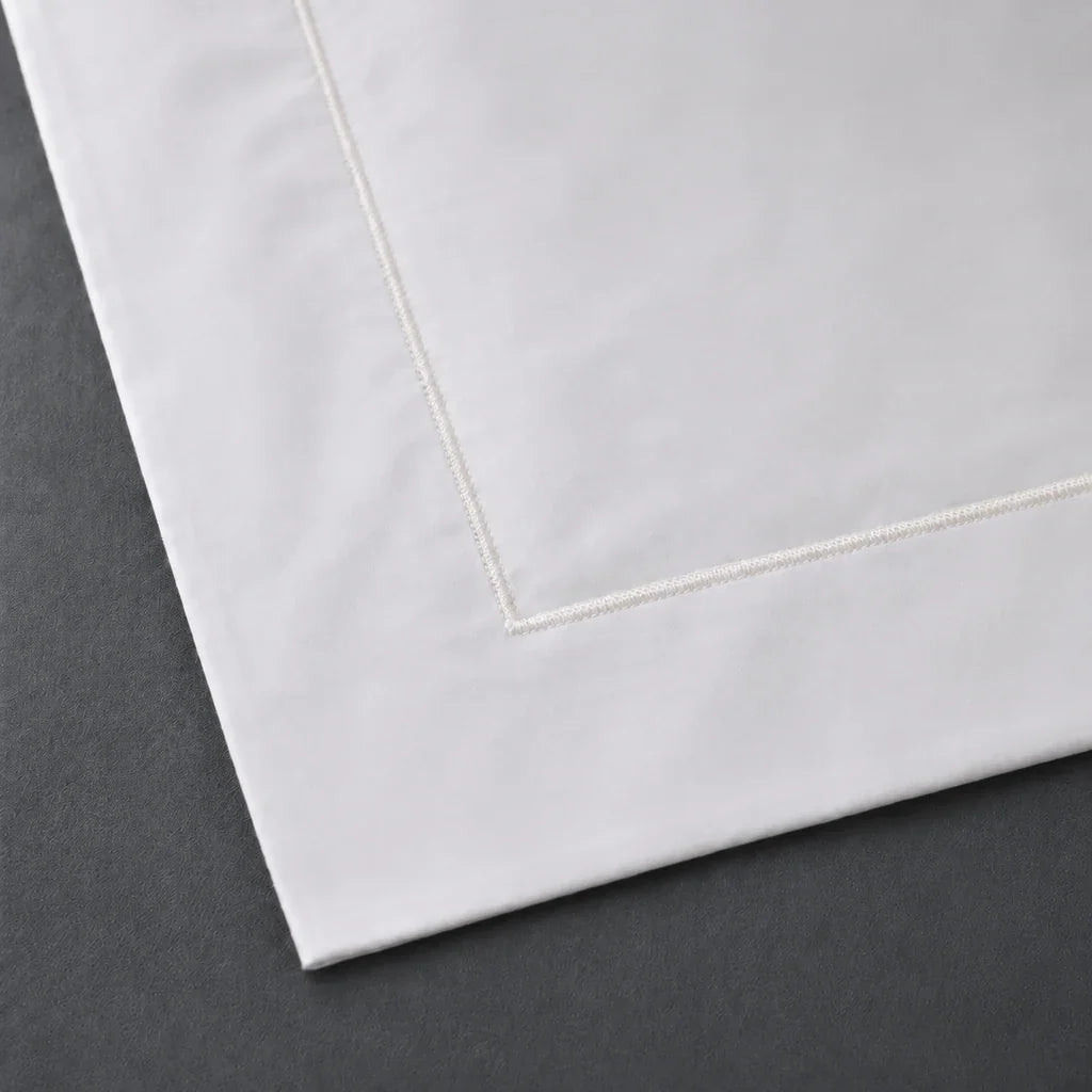 Close-up of a White 100% cotton percale 300TC Oxford pillow case with Cream one-row satin stitch.