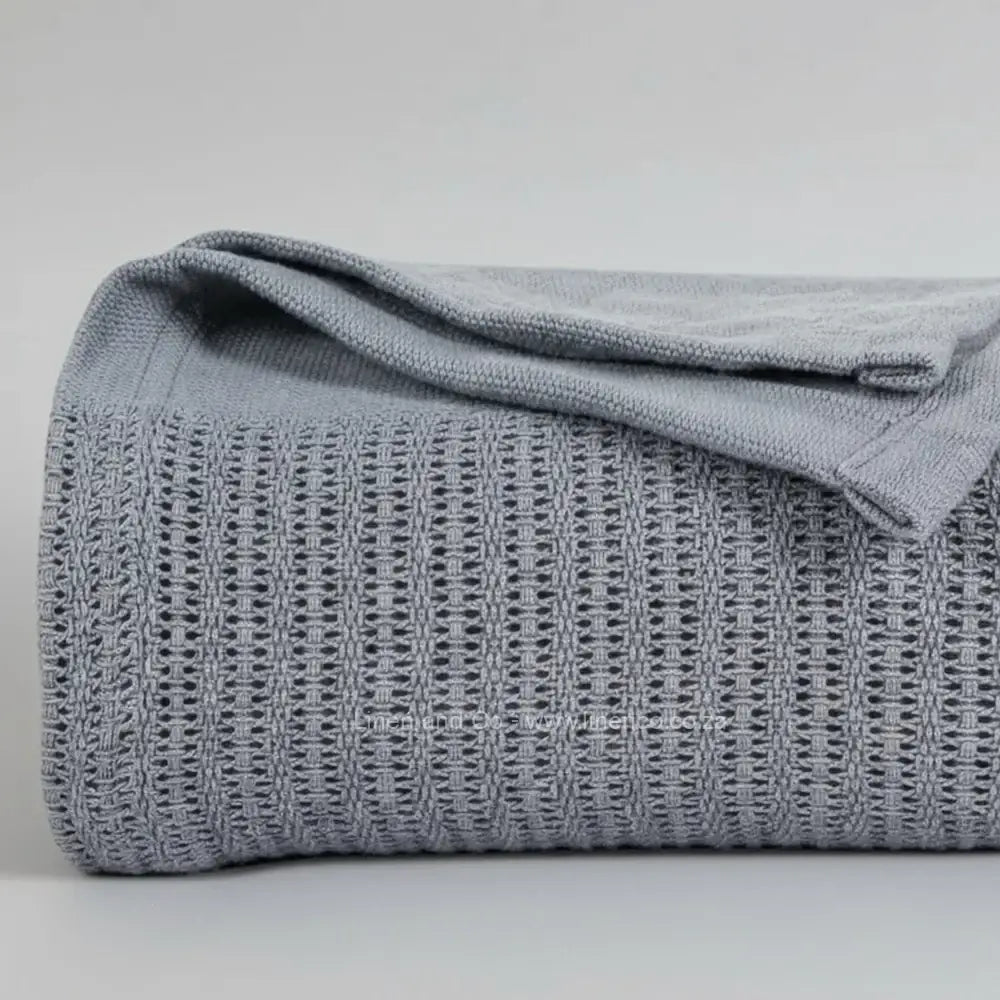 dark grey cotton cellular blanket showing textured waffle weave fabric on neutral grey background—soft, breathable bedding by Linen & Co
