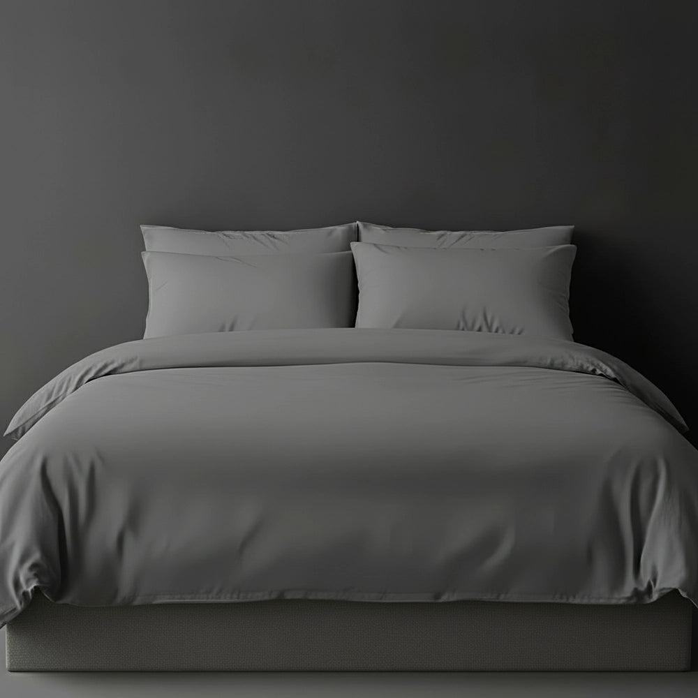 Grey plain duvet cover with pillows on bed by Linen and Co - luxury hospitality bed linen