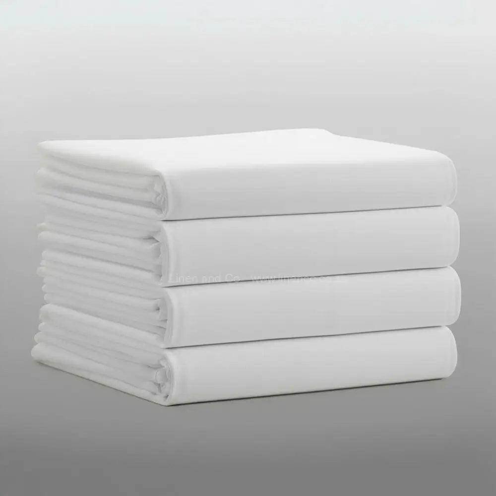 Stack of folded white percale 200TC flat sheets on light grey background—durable, colour-fast flat sheets by Linen & C