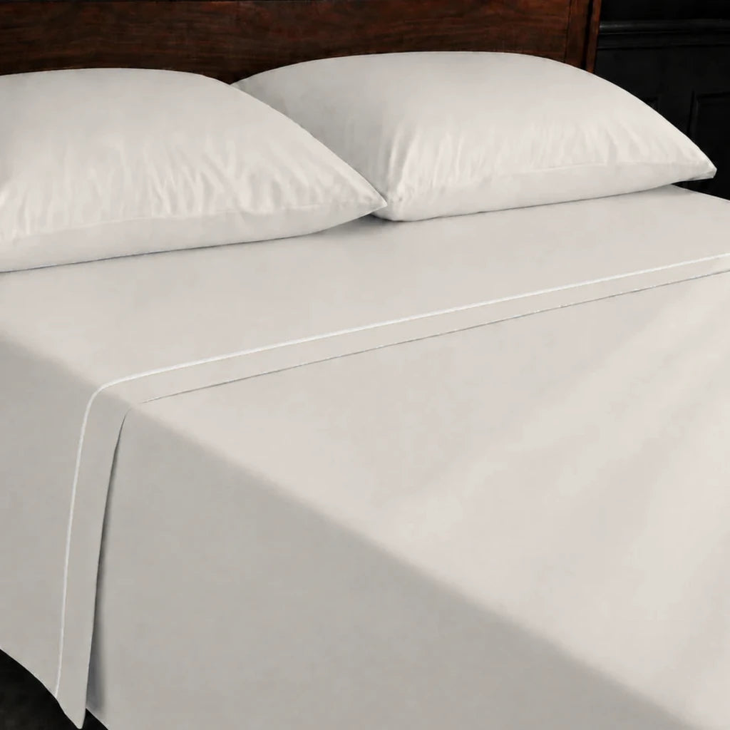 Ivory Cream 100% Cotton Percale 200TC flat sheet with Cream one-row satin stitch - on the bed - Linen and Co