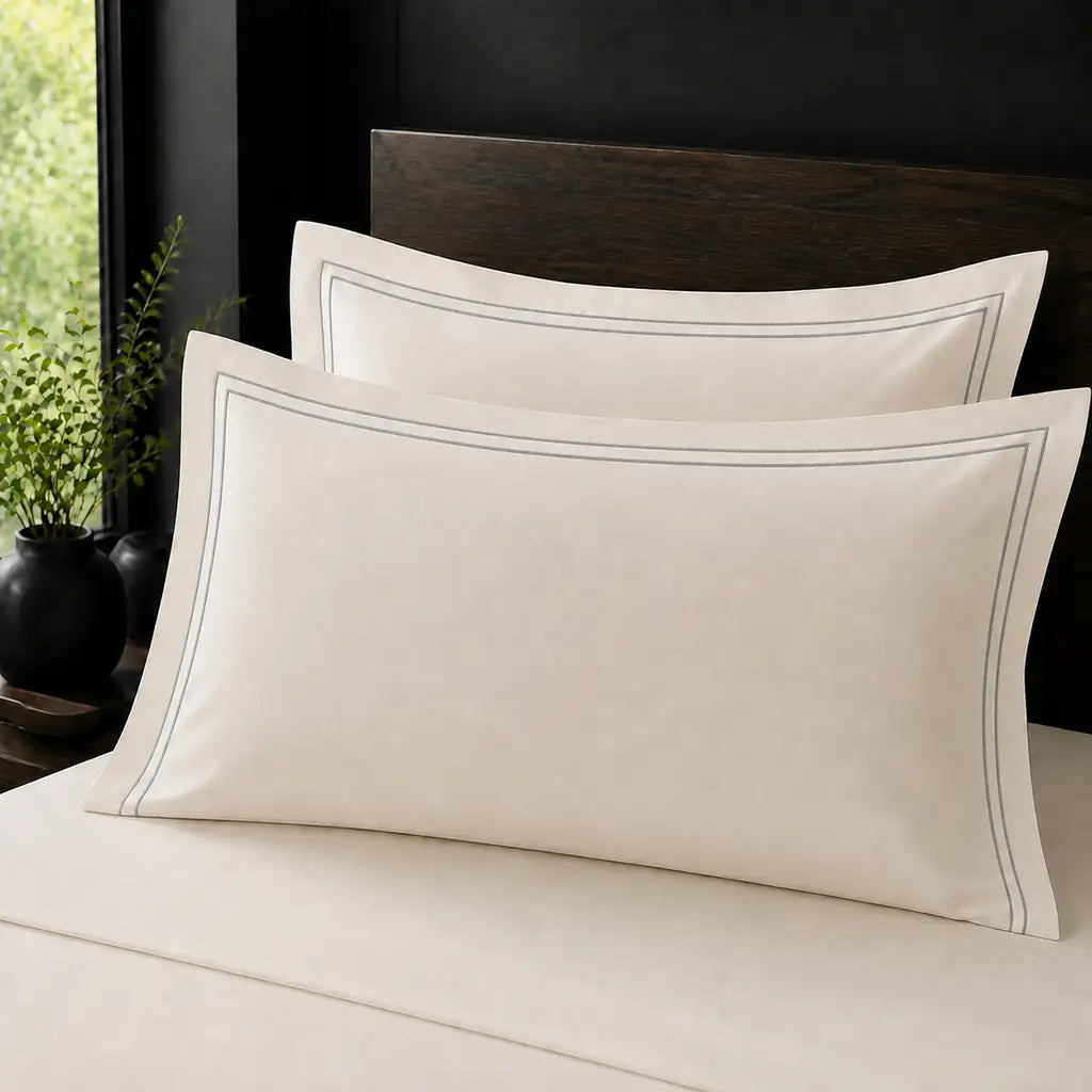 Ivory Cream 100% Cotton Percale 200TC Oxford pillow cases on a bed with Grey two-row satin stitch - Linen and Co