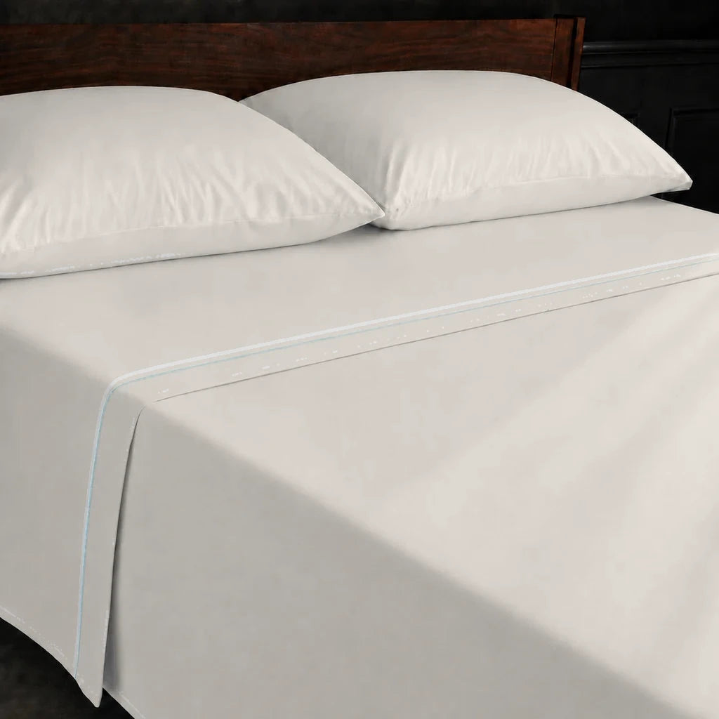 Ivory Cream Polycotton Percale 200TC flat sheet with Duck Egg one-row satin stitch - on the bed - Linen and Co