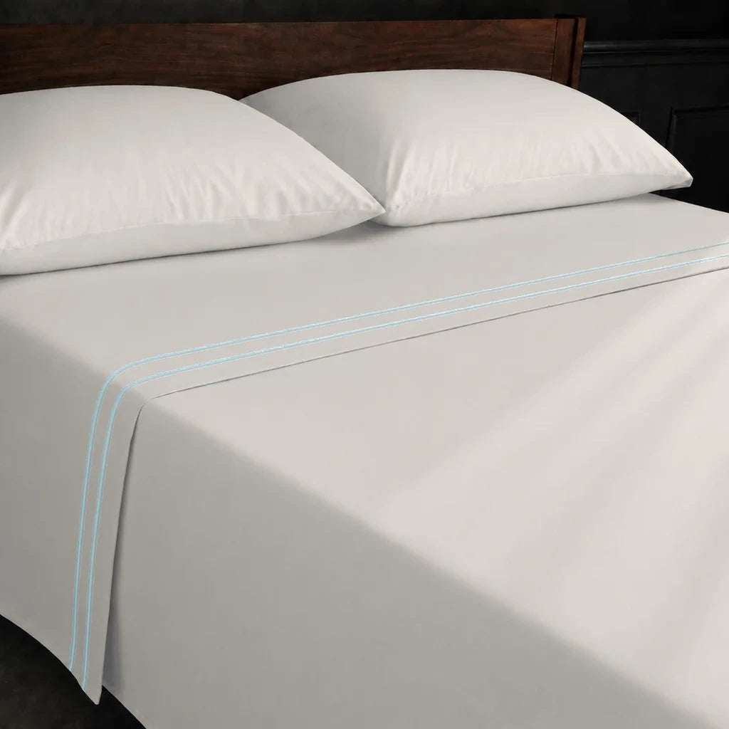 Ivory Cream Polycotton Percale 200TC flat sheet with Duck Egg two-row satin stitch - on the bed - Linen and Co