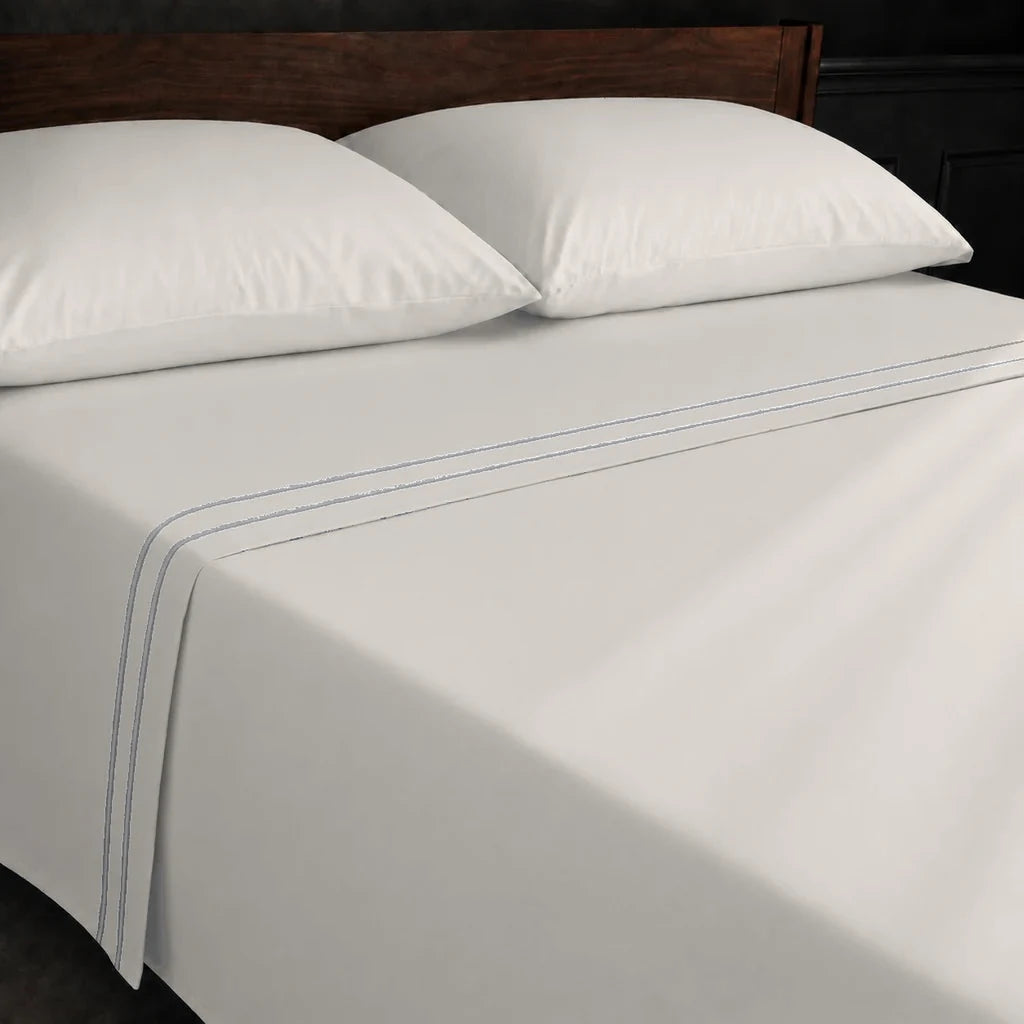 Ivory Cream Polycotton Percale 200TC flat sheet with Grey two-row satin stitch - on the bed - Linen and Co