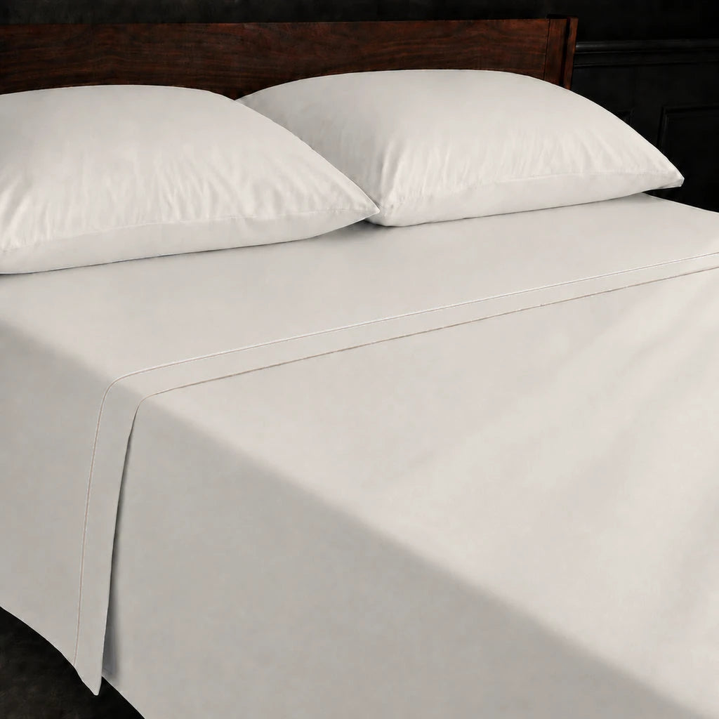 Ivory Cream Polycotton Percale 200TC flat sheet with Stone one-row satin stitch - on the bed - Linen and Co