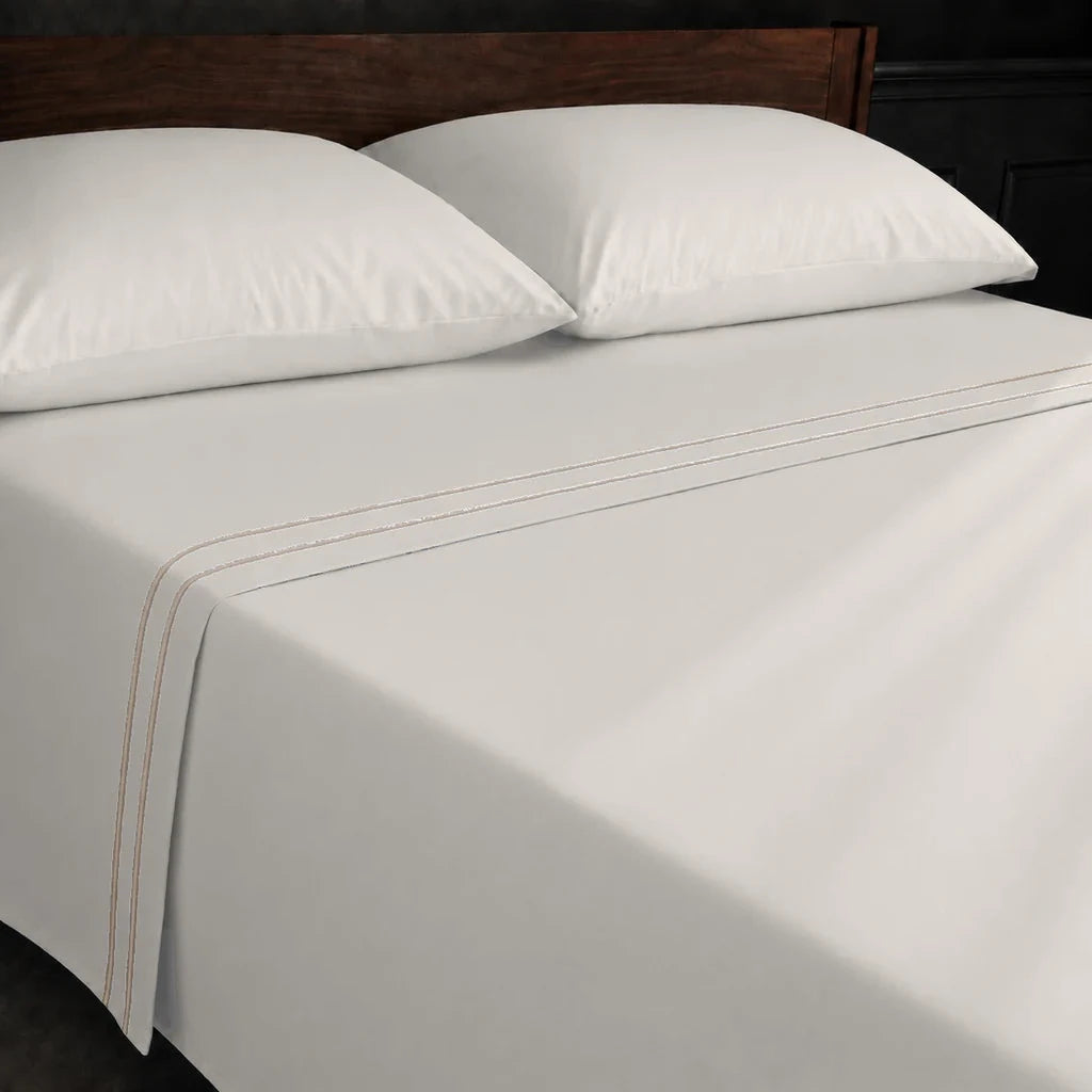 Ivory Cream Polycotton Percale 200TC flat sheet with Stone two-row satin stitch - on the bed - Linen and Co
