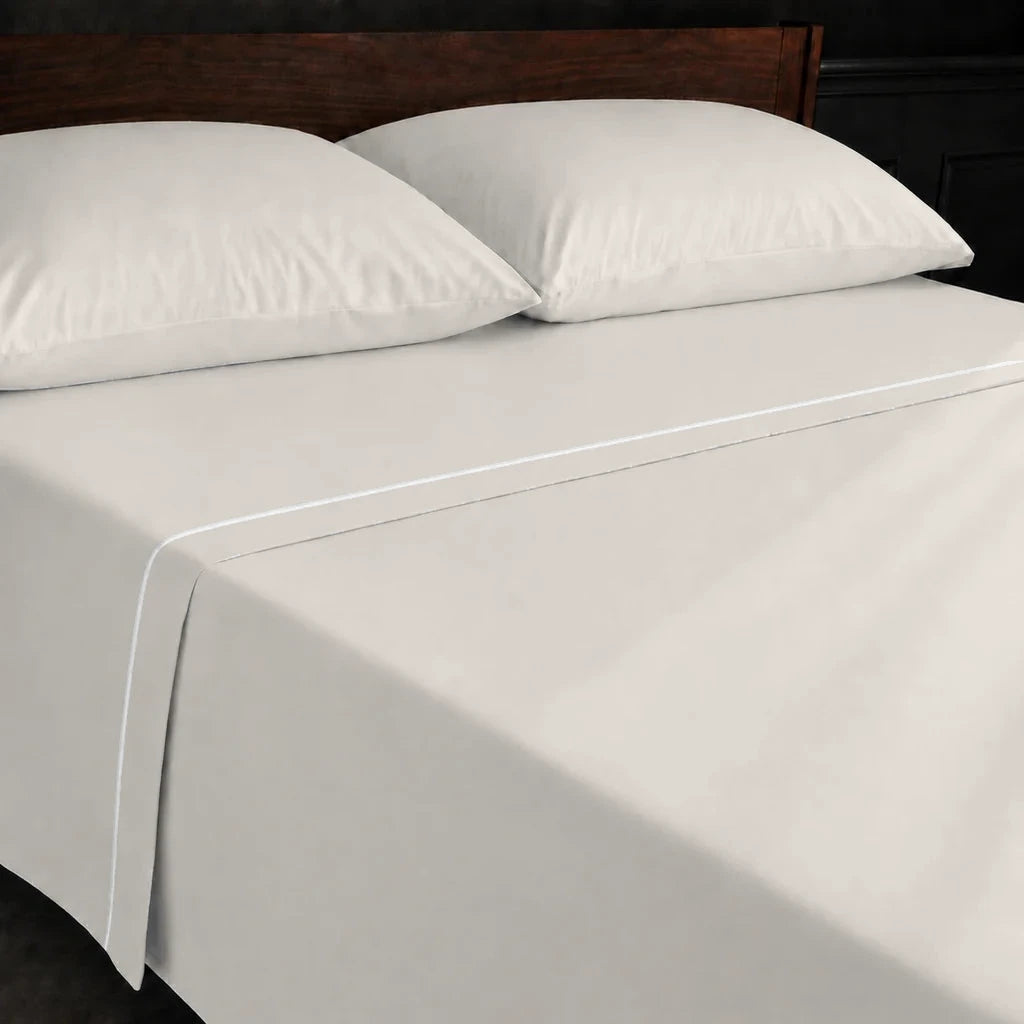 Ivory Cream Polycotton Percale 200TC flat sheet with White one-row satin stitch - on the bed - Linen and Co