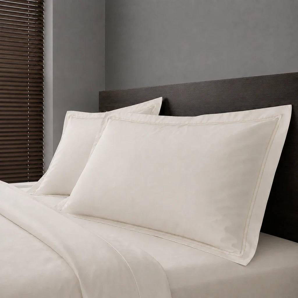 Ivory Cream Polycotton Percale 200TC Oxford pillow cases on a bed with Cream two-row satin stitch - Linen and Co