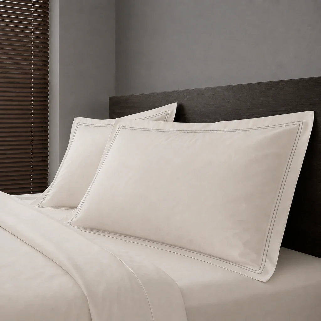 Ivory Cream Polycotton Percale 200TC Oxford pillow cases on a bed with Grey two-row satin stitch - Linen and Co