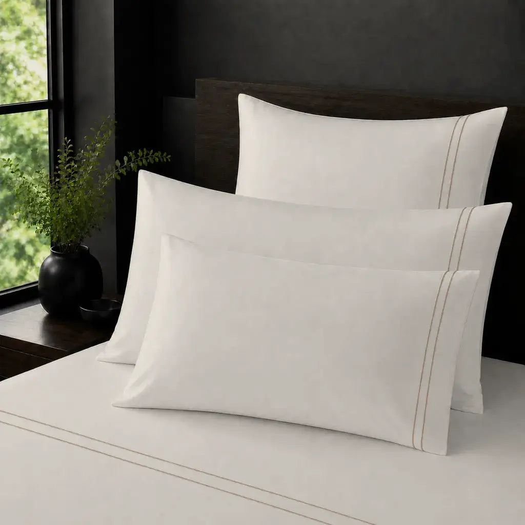Cream Polycotton Percale 200TC plain pillow cases with Stone two-row satin stitch - on the bed - Linen and Co
