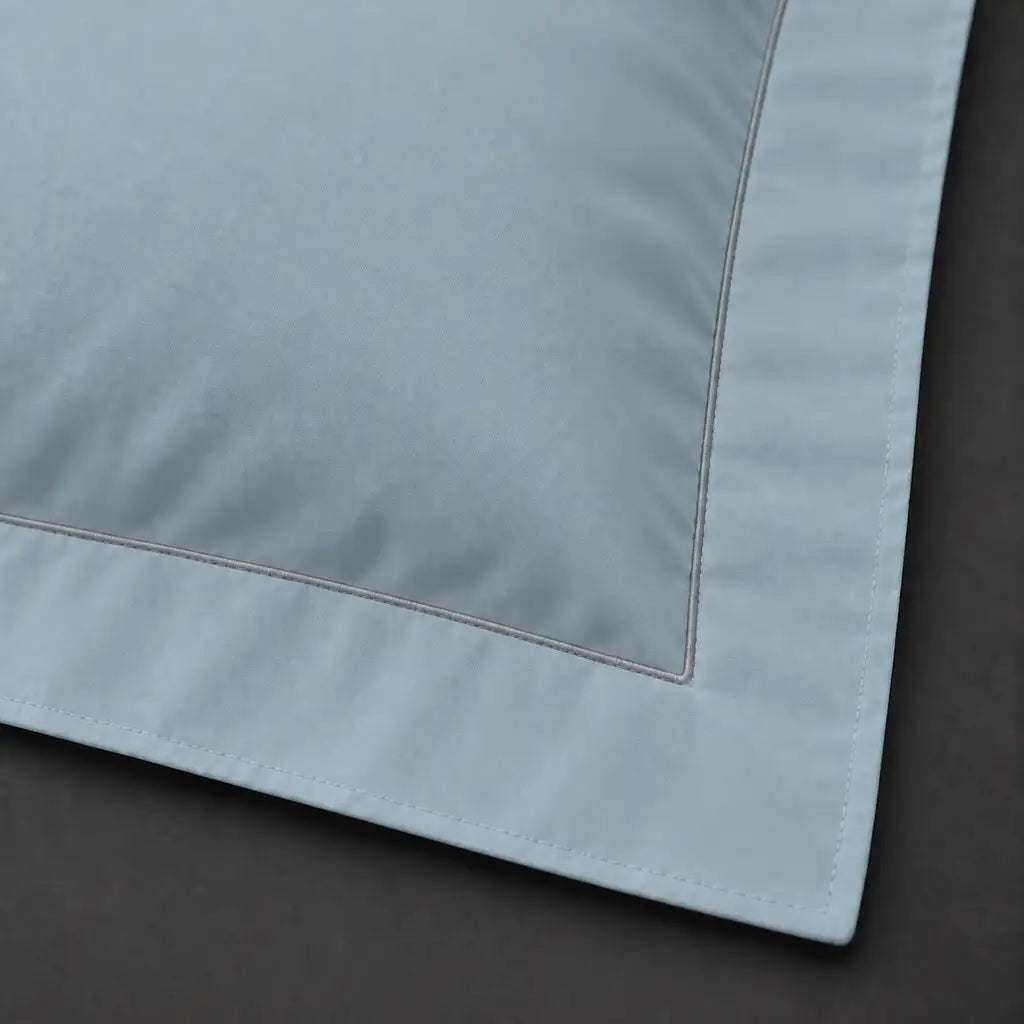 Close-up of duck egg Oxford pillowcase with one row grey satin stitch border by Linen and Co