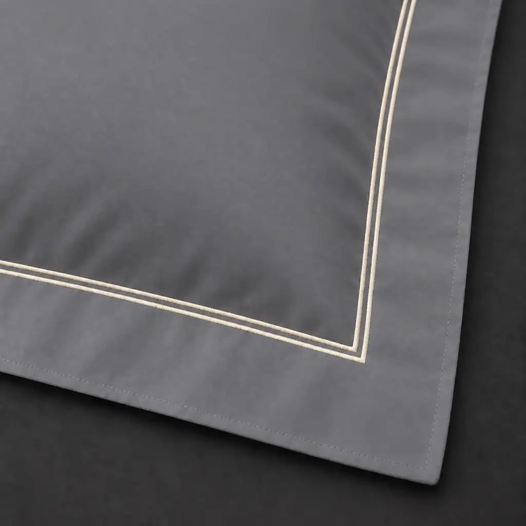 Close-up of grey Oxford pillowcase with two row cream satin stitch border by Linen and Co