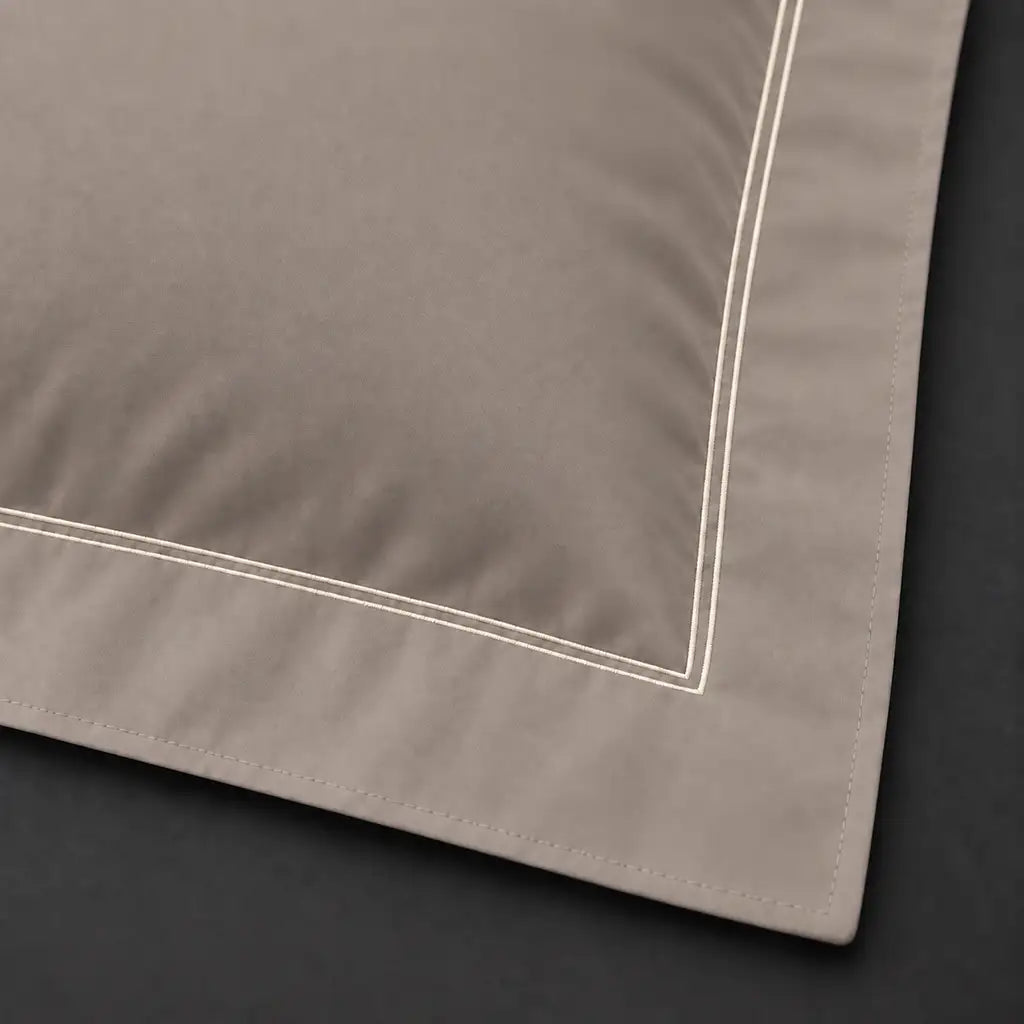 Close-up of stone Oxford pillowcase with two row cream satin stitch border by Linen and Co
