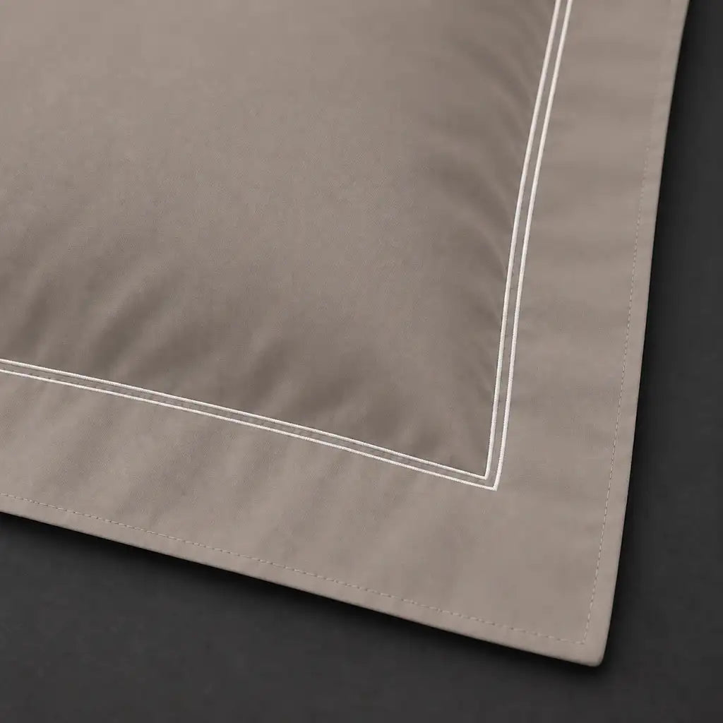 Close-up of stone Oxford pillowcase with two row white satin stitch border by Linen and Co
