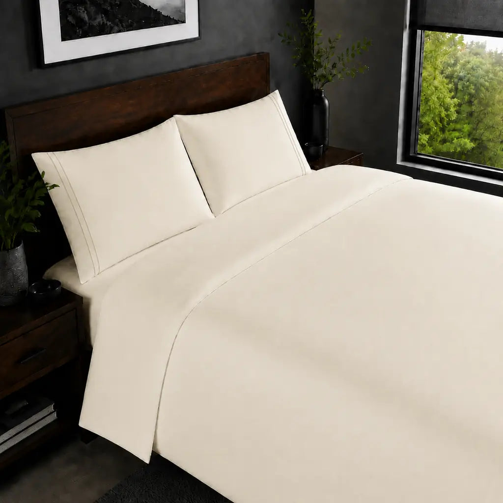 Cream 200TC plain duvet cover with Cream two row satin stitch - on the bed - Linen and Co