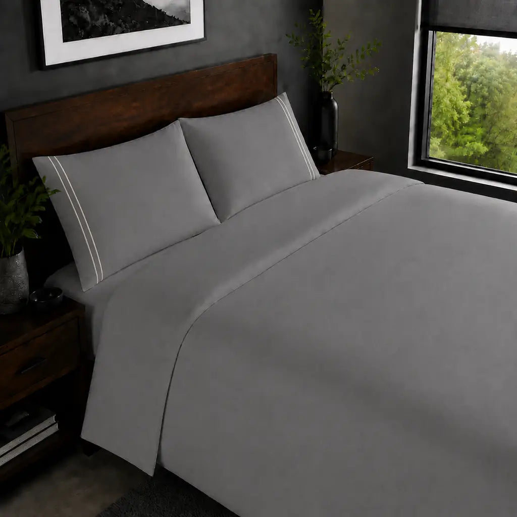 Grey 200TC plain duvet cover with Cream two row satin stitch - on the bed - Linen and Co
