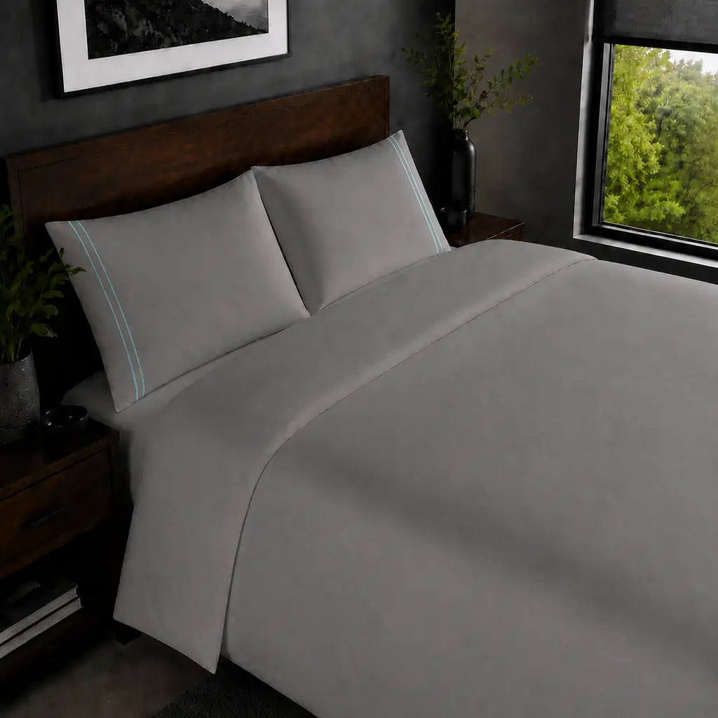 Grey 200TC plain duvet cover with Duck Egg two row satin stitch - on the bed - Linen and Co