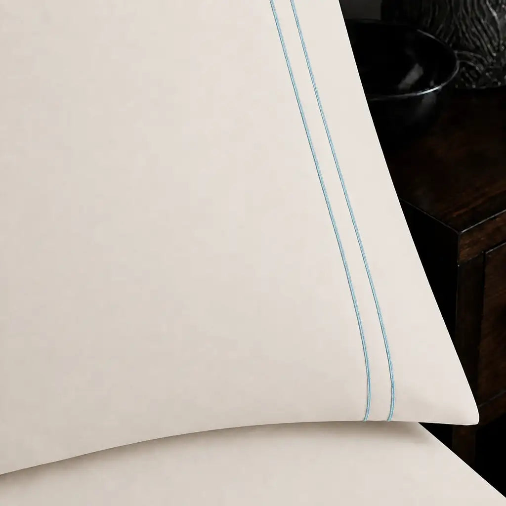 Close-up of cream pillowcase with two row duck egg satin stitch border by Linen and Co