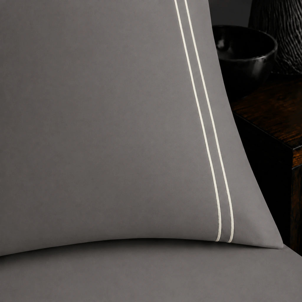 Close-up of grey pillowcase with two row cream satin stitch border by Linen and Co