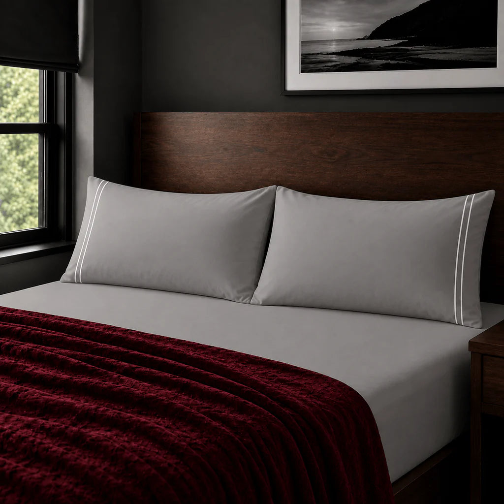 Plain grey 200TC polycotton percale pillowcases with two row white satin stitch border by Linen and Co