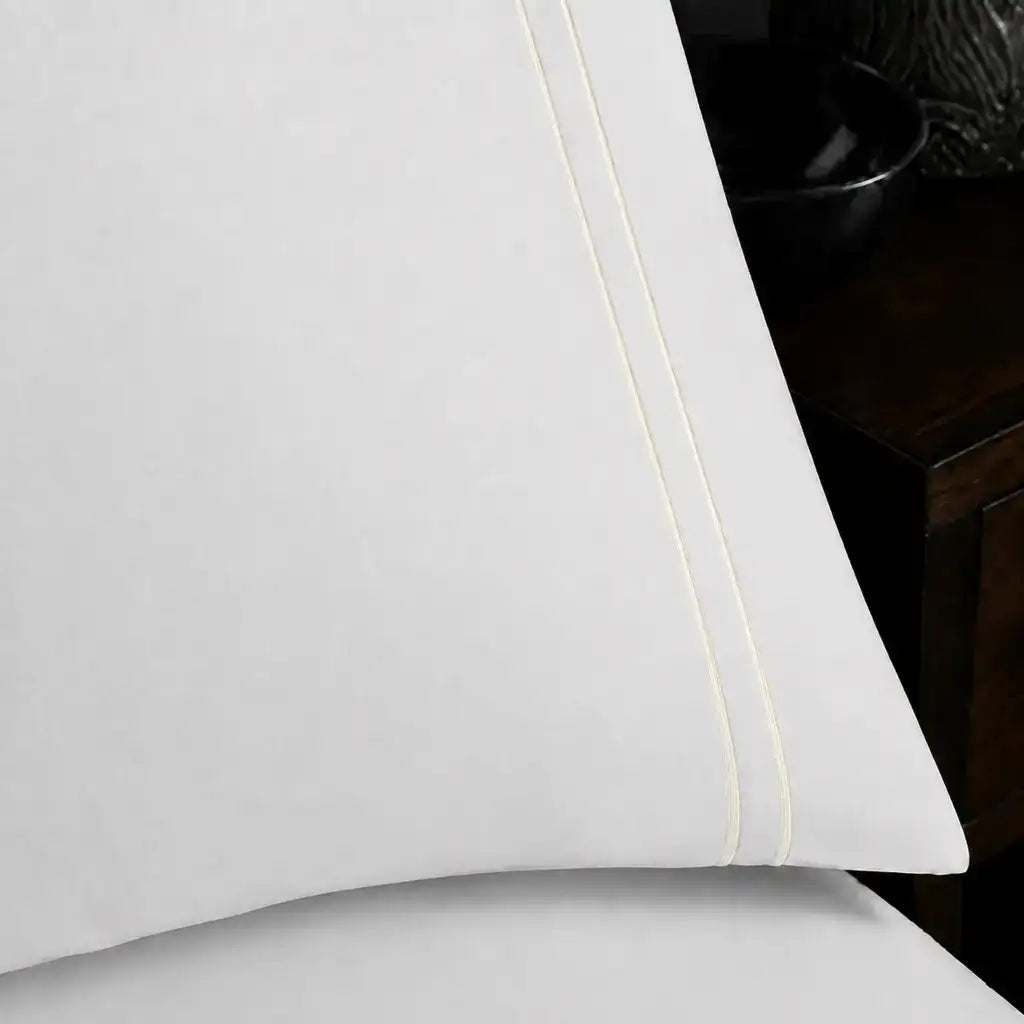 Close-up of white pillowcase with two row cream satin stitch border by Linen and Co