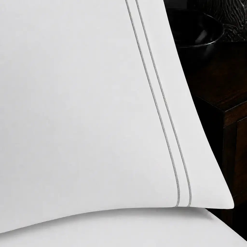 Close-up of white pillowcase with two row grey satin stitch border by Linen and Co