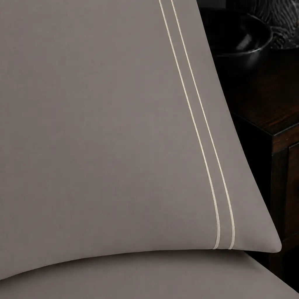 Close-up of stone pillowcase with two row cream satin stitch border by Linen and Co
