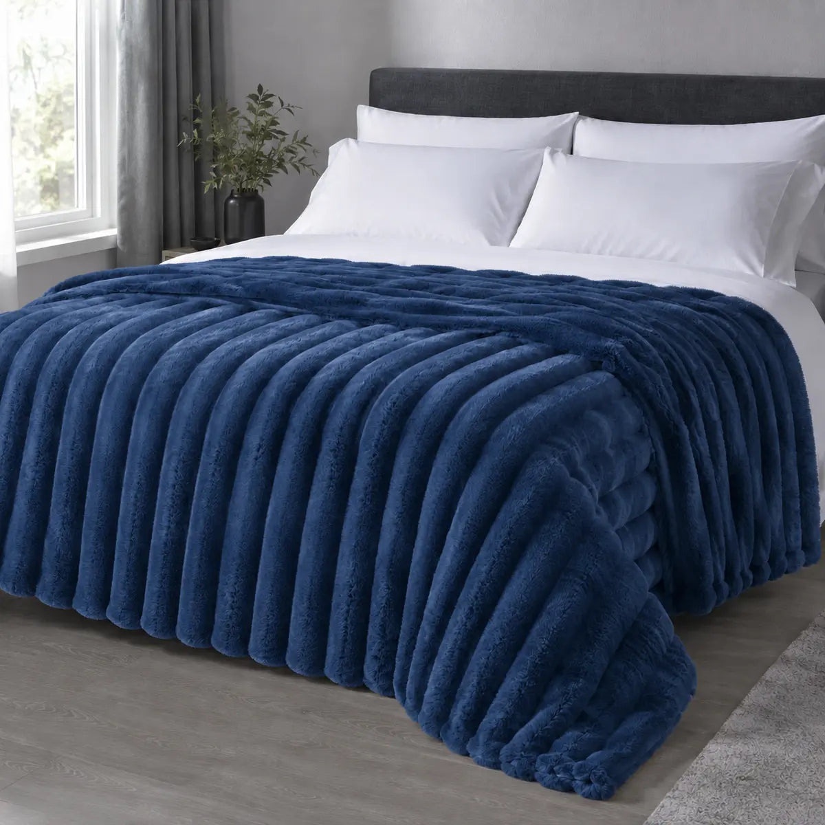 Blue ribbed faux fur blanket draped over a bed
