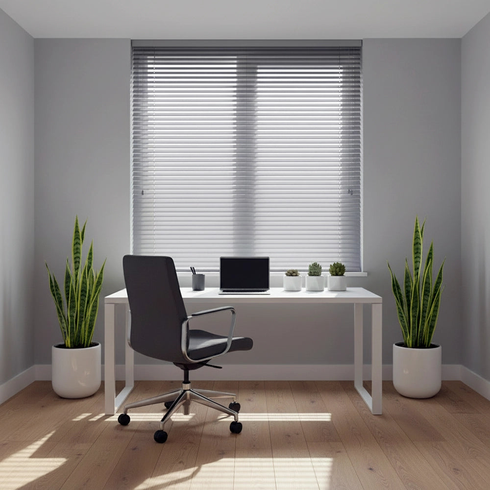 Silver aluminium office blind in a modern office space by Linen and Co, featuring a white desk, black chair, and indoor plants